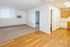 Bright and spacious open-plan living area with a blend of elegant hardwood and cozy carpet flooring, adjacent to a functional kitchen with classic cabinetry.