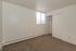 Spacious bedroom with a large window featuring natural light and a built-in closet, ideal for cozy urban living.