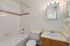 Bright and inviting bathroom featuring classic white tiles, a sleek bathtub, and a modern vanity for a refreshing feel.