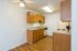 Charming kitchen with warm wood cabinetry, efficient appliances, and sleek countertops, perfect for modern living.
