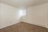 Bright and cozy room with plush carpet flooring and a large window, perfect for personalization and comfort.