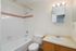 Bright and inviting bathroom with elegant bathtub, sleek vanity, and classic tile design.