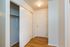 Bright entryway featuring elegant hardwood floors and ample closet space with modern sliding doors.