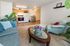 Inviting open-concept living space with cozy seating, elegant coffee table, and adjacent dining area featuring a modern kitchen.