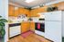 Charming kitchen with modern appliances, wooden cabinetry, and vibrant greenery accents.