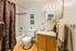 Inviting bathroom with elegant wooden cabinetry, sleek countertop, decorated with chic floral touches, and a cozy tub.