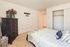 Elegant bedroom with a sophisticated decor, featuring a stylish dresser, spacious closet, and cozy bed with decorative pillows.