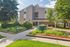 Charming apartment building with modern exterior, surrounded by lush gardens and vibrant greenery, offering a welcoming residential atmosphere.