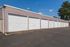 Modern apartment complex with multiple secure garage units under a clear blue sky, offering ample parking and convenience.