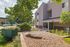 Charming apartment exterior with well-maintained landscaping, vibrant flowers, and a welcoming entryway.