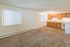 Inviting open-plan living and kitchen area with cozy carpeting and ample natural light.