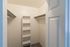 Spacious walk-in closet with ample shelving and hanging space, perfect for organized living.