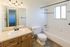 Bright and inviting bathroom with elegant vanity, large mirror, and relaxing bathtub, perfect for unwinding.