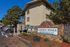 Charming Garden Pines Apartments entrance showcasing beautiful stone signage and lush greenery, ideal for affordable living.