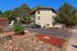 Charming apartment building at Garden Pines, surrounded by lush trees and well-maintained landscaping, offering a peaceful residential ambiance.