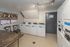 Modern laundry room with multiple washing machines, sleek decor, and ample folding space for convenient living.