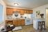 Cozy kitchen with wooden cabinetry, modern appliances, and a charming breakfast bar for two.
