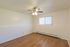 Bright and airy room with warm wood flooring and a modern ceiling fan, ideal for personalized home decor.