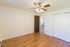 Bright and cozy room with elegant wood flooring and a ceiling fan, perfect for comfortable living.