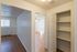 Bright apartment interior featuring sleek hardwood floors, spacious shelving, and a ceiling fan in a cozy room setting.