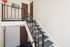 Charming apartment stairway with elegant railing and plush carpeting, showcasing inviting entry doors and bright walls.