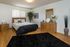Elegant bedroom with cozy queen-sized bed, chic wooden dresser, stylish d&eacute;cor, and lush green plant, offering a serene and inviting atmosphere.