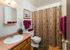 Inviting bathroom with elegant wood cabinetry, stylish fixtures, and a charming shower curtain, creating a warm and cozy atmosphere.