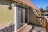 Inviting balcony with sliding glass doors, offering a cozy outdoor space and charming views, perfect for enjoying sunny days.