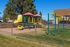 Inviting playground area with vibrant slide and climbing equipment, perfect for children's outdoor fun and family enjoyment in a residential community.