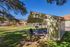 Charming outdoor pavilion with picnic tables and scenic mountain views in a sunny community park setting.