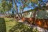 Charming apartment exterior with lush trees and a sunny, fenced backyard.