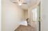 Inviting hallway with plush carpet and ceiling fan, leading to bright bedrooms in a cozy, modern apartment.