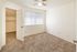 Bright and airy bedroom with plush carpeting, featuring a ceiling fan and walk-in closet.