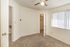 Bright, carpeted bedroom with a ceiling fan, large window, and walk-in closet.