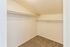 Spacious walk-in closet with ample shelving and soft carpet flooring, perfect for organizing your wardrobe efficiently.