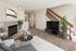 Cozy living room with elegant decor, featuring a plush carpet, modern TV stand, and a charming fireplace next to a staircase.