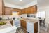 Charming kitchen with warm wooden cabinets, modern appliances, and a cozy dining area filled with natural light.