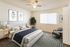 Inviting bedroom with modern decor, featuring a cozy bed, stylish artwork, and ample natural light from large windows.