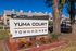 Inviting Yuma Court townhomes sign with attractive landscaping and modern architecture in the background.