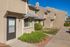 Inviting townhouse exterior showcasing modern architecture, well-maintained landscaping, and ample sunlight.