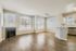 Bright open-concept living space featuring hardwood floors, large windows, and a modern fireplace.