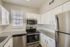 Modern kitchen with sleek stainless steel appliances, elegant granite countertops, and bright white cabinetry.