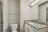 Modern bathroom featuring elegant granite countertop and sleek white cabinetry, creating a stylish and inviting space.