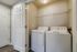 Efficient in-unit laundry space featuring modern washer and dryer with ample shelving, enhancing convenience and comfort.