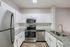Modern kitchen with sleek stainless steel appliances, granite countertops, and elegant white cabinetry.