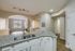 Bright modern apartment kitchen with elegant granite countertops, open living space, and stylish arched entryway.