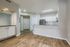 Inviting open kitchen with sleek white cabinetry, granite countertops, and modern stainless steel appliances, perfect for entertaining in style.