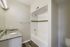 Elegant bathroom featuring a sleek granite countertop, bright lighting, and modern tub with stylish tile accents.