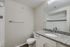 Bright and modern bathroom featuring elegant granite countertops, sleek fixtures, and a spacious mirror for a luxurious feel.