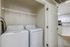 Chic apartment laundry area with modern washer and dryer, adjacent to a stylish kitchen with sleek appliances.
